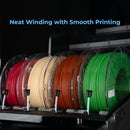 Five spools of 3D printer filament in red, cream, orange-brown, and green, wound neatly on a black machine with blue text reading 'Neat Winding with Smooth Printing' at the top.