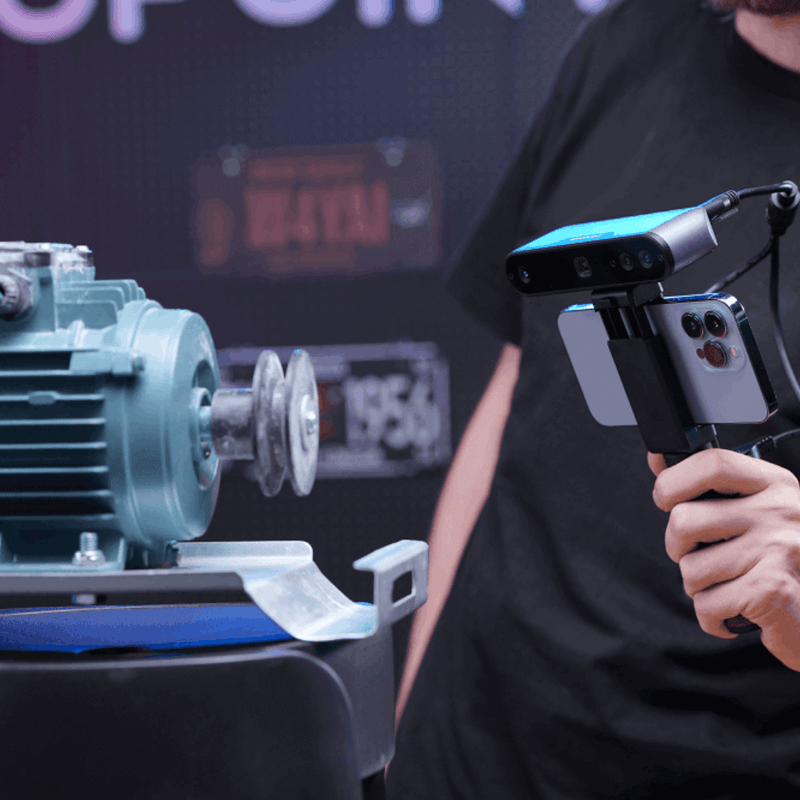 Revopoint mobile-scanning setup showing a person holding a screen-equipped device beside a mechanical component.